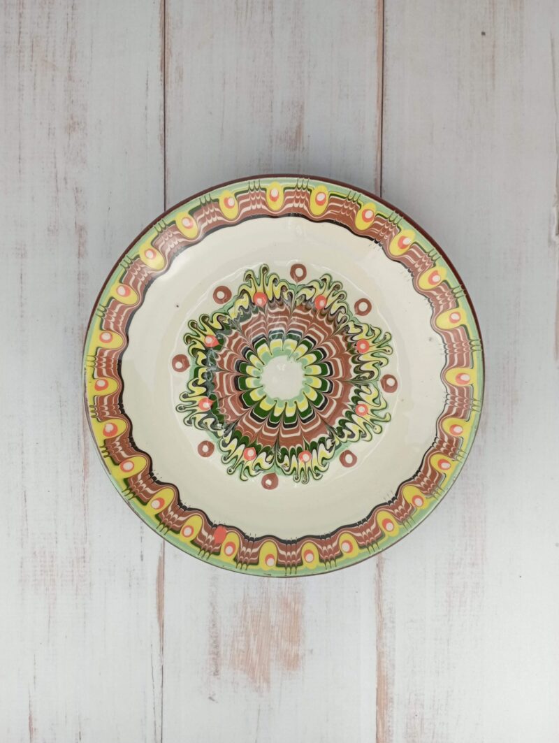Obrazek przedstawia: bułgarski gliniany kremowy talerz śniadaniowy, z wielobarwnym ludowym wzorem, o średnicy ok. 22cm. Oryginalna ceramika bułgarska, talerz ręcznie wykonany i malowany.